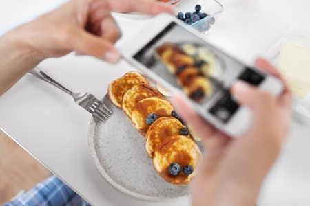 hands with smartphones photographing foodの写真素材