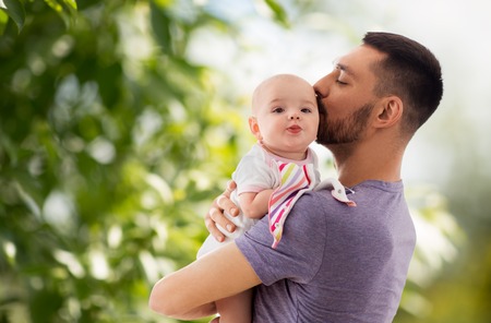 father kissing little baby daughter
