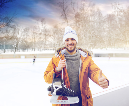 happy young man showing thumbs up on skating rinkの写真素材