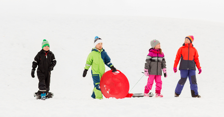 happy little kids with sleds in winterの写真素材