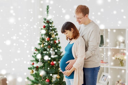 pregnant wife with husband at home at christmasの写真素材