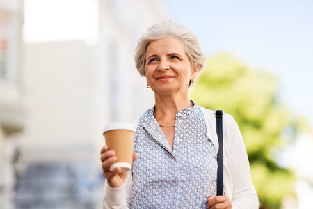senior woman drinking coffee at summer cityの写真素材