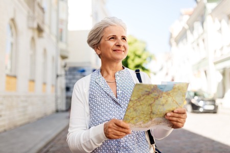 senior woman or tourist with map on city streetの写真素材