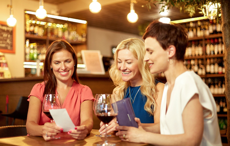 women looking at bill at wine bar or restaurantの写真素材