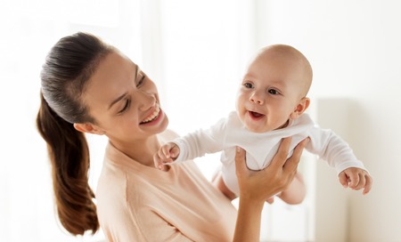 happy mother playing with little baby boy at homeの写真素材