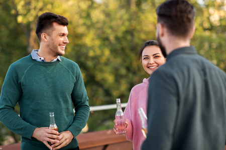 happy friends with drinks at rooftop partyの写真素材