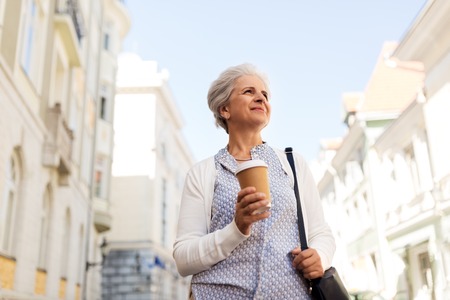 senior woman drinking coffee at summer cityの写真素材
