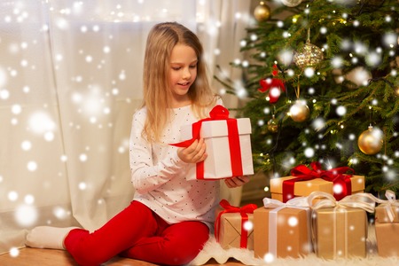smiling girl with christmas gift at homeの写真素材