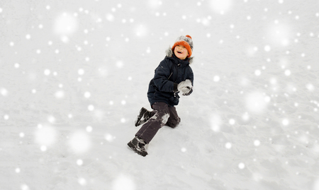 happy little boy playing with snow in winterの写真素材