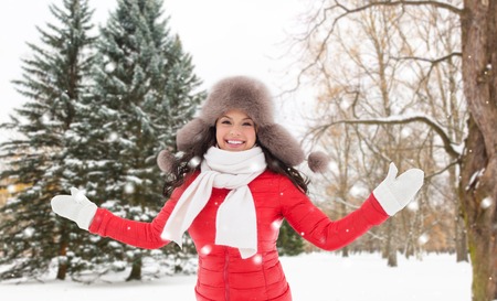 happy woman in fur hat over winter forestの写真素材