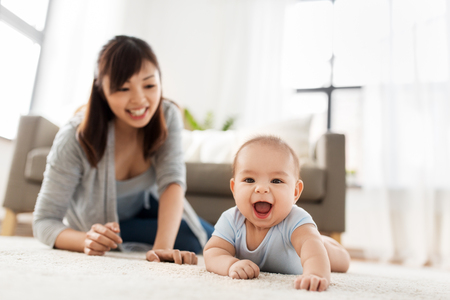 happy little asian baby boy with mother at homeの写真素材