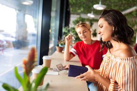 female friends paying for coffee at cafe