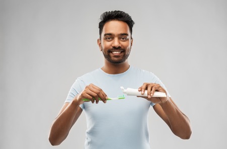 indian man with toothbrush and toothpaste