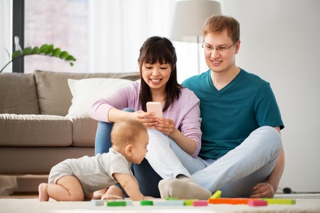 mixed race family with baby son playing at home