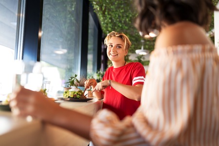 female friends eating at restaurantの写真素材