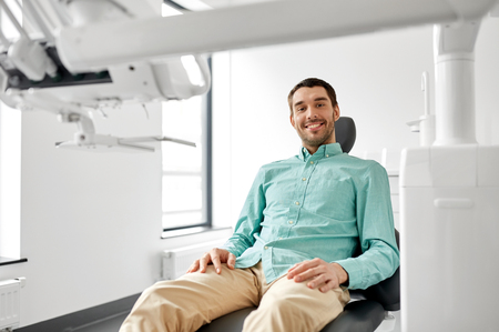 happy smiling male patient at dental clinicの写真素材