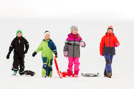 happy little kids with sleds in winterの写真素材
