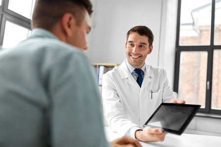 doctor with tablet computer and patient at clinicの写真素材
