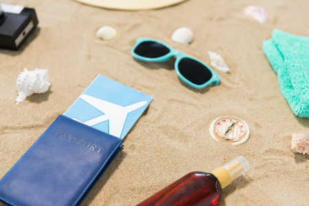 travel tickets, camera and hat on beach sandの写真素材