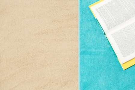 book on beach towel on sandの写真素材