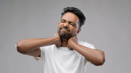 tired indian man suffering from neck painの写真素材