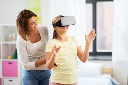 mother and daughter in vr glasses playing at homeの写真素材