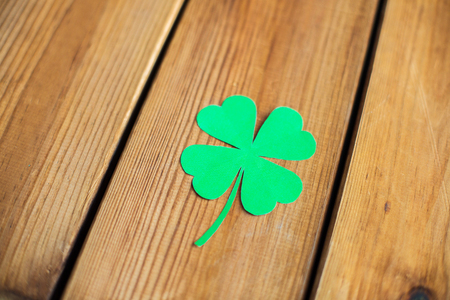 green paper four-leaf clover on wooden backgroundの写真素材