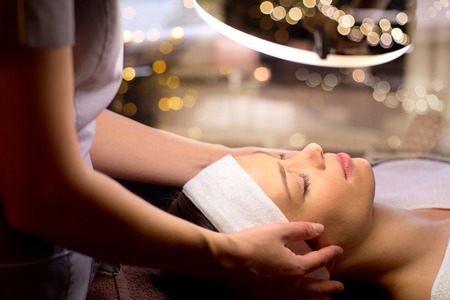 beautician doing face massage to woman at spaの写真素材