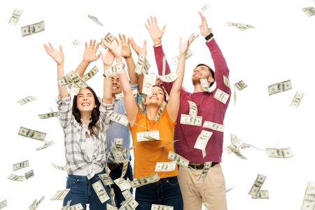 happy friends picking money falling from up aboveの写真素材