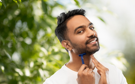 indian man shaving beard with razor bladeの写真素材