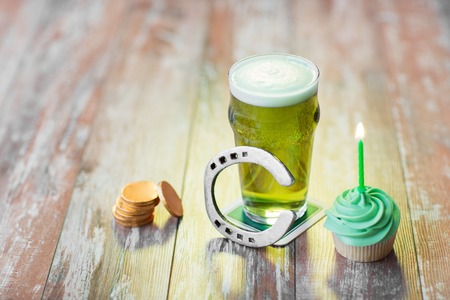 glass of beer, cupcake, horseshoe and gold coinsの写真素材