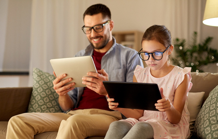 father and daughter with tablet computers at homeの写真素材