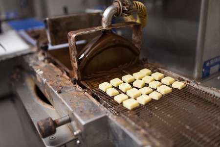 Candies processing by chocolate coating machineの写真素材