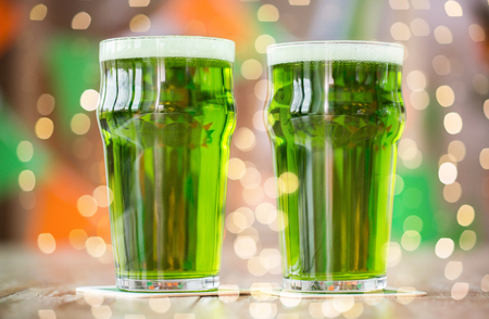 two glasses of green beer on wooden tableの写真素材