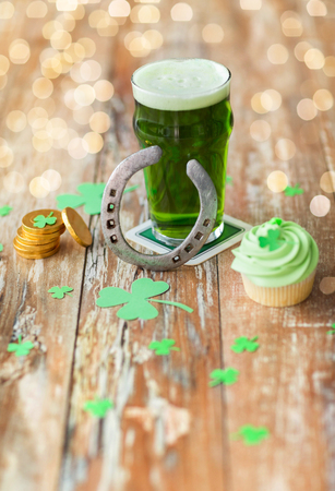 glass of beer, cupcake, horseshoe and gold coinsの写真素材