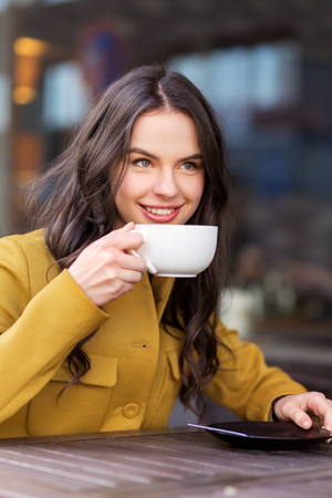 teenage girl drinking hot chocolate at city cafeの写真素材