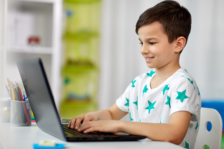 student boy typing on laptop computer at homeの写真素材