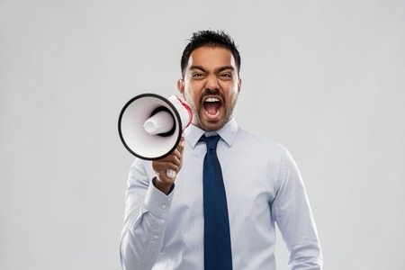 indian businessman screaming over greyの写真素材