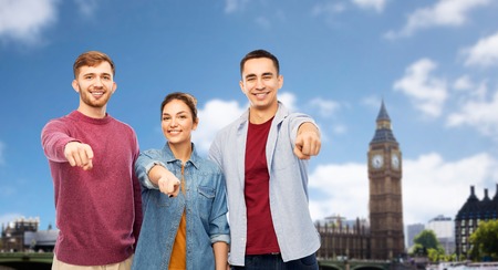 smiling friends pointing at you over londonの写真素材