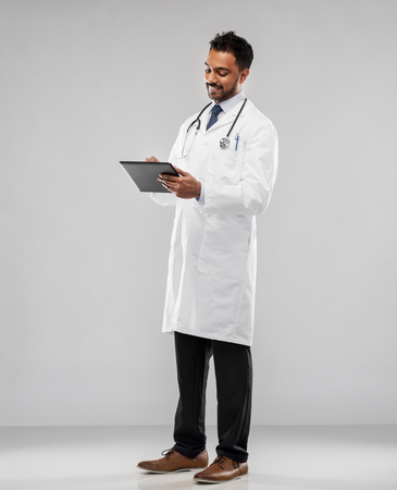 smiling indian male doctor with tablet computerの写真素材