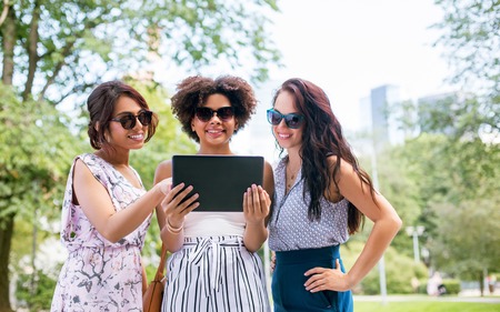 women with tablet computer on street in summerの写真素材
