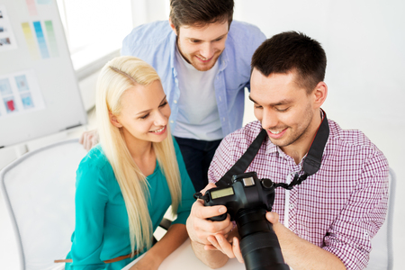 photography and creative people concept - photographers with camera at photo studioの写真素材