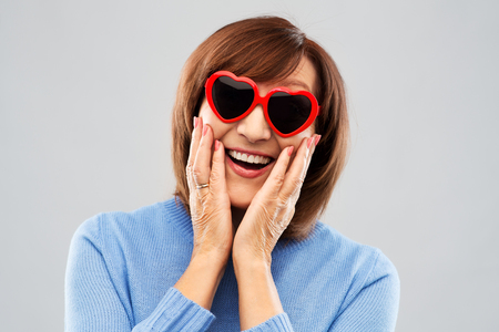 smiling senior woman in heart-shaped sunglassesの写真素材