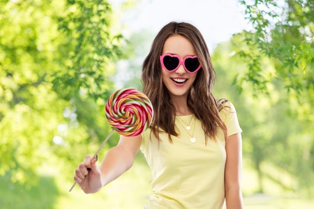 teenage girl in sunglasses with lollipopの写真素材