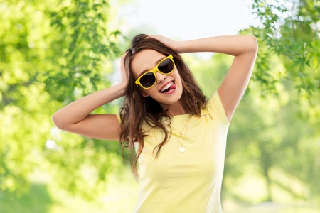 teenage girl in yellow sunglasses and t-shirtの写真素材