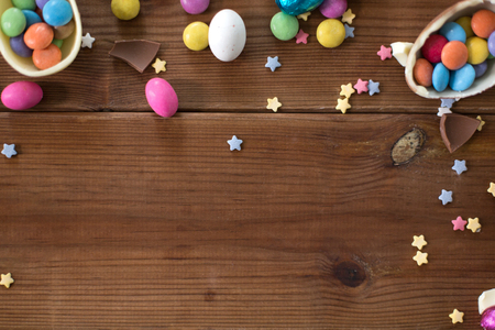 chocolate eggs and candy drops on wooden tableの写真素材