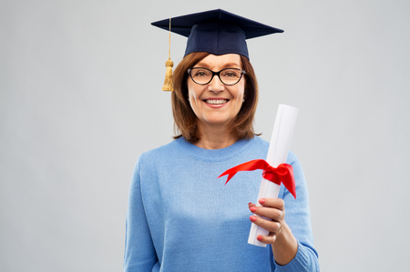 happy senior graduate student woman with diplomaの写真素材