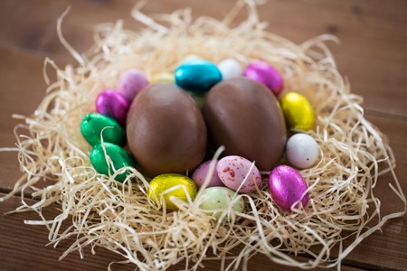 chocolate eggs in foil wrappers in straw nest