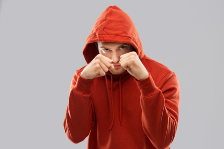 man in red hoodie fighting with fists or boxingの写真素材