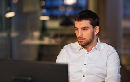 businessman with computer working at night office